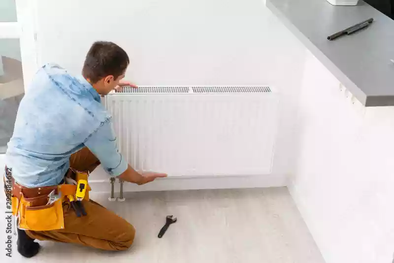 Une personne qui installe un radiateur